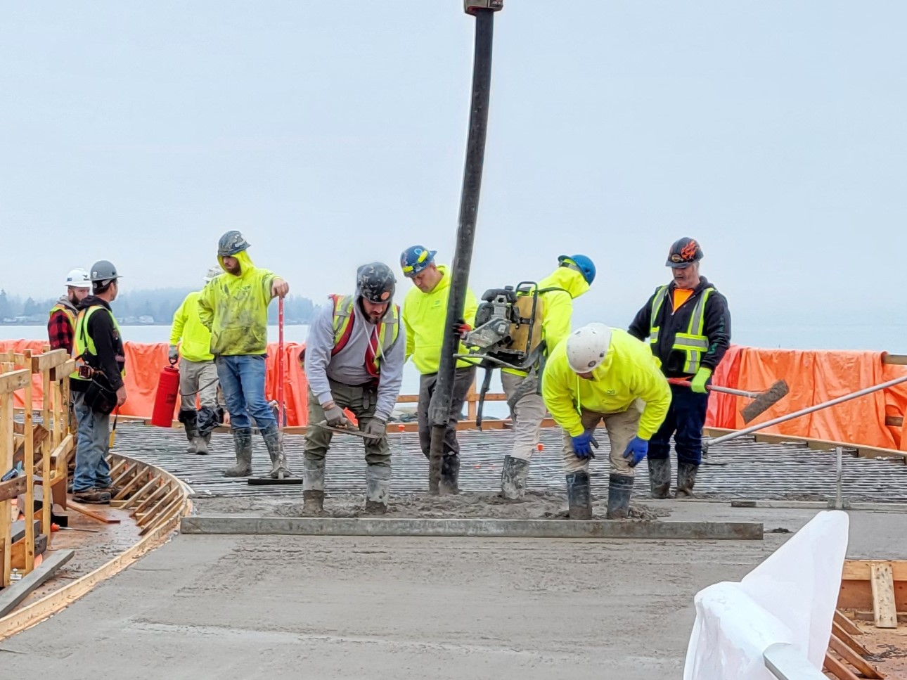 The Waterfront Viewing Platform and Walkway being built by 9 construction workers with orange barriers around them.