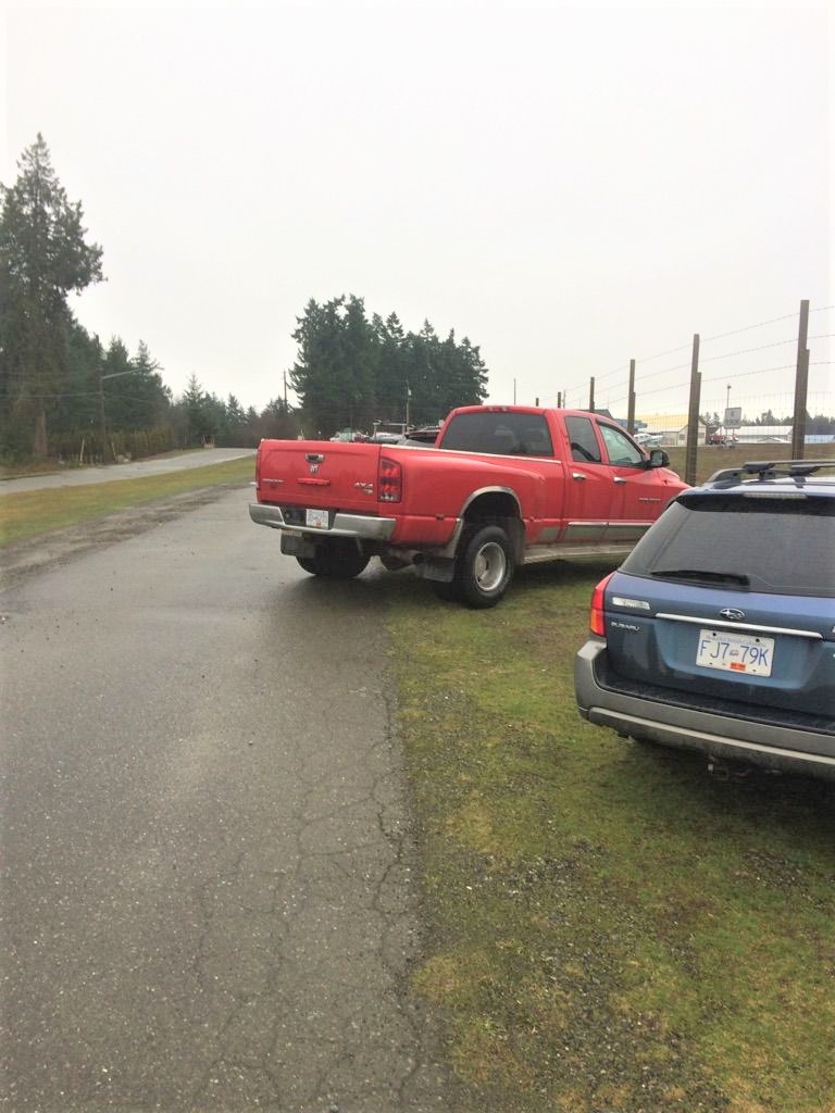 image of two trucks angle parked in dirt at the airport