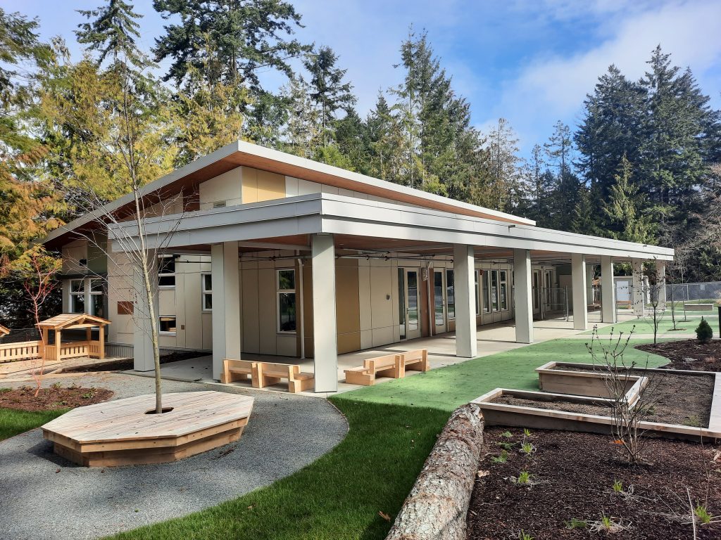 Photos of finished child care centre from the outside grounds with garden beds and play area