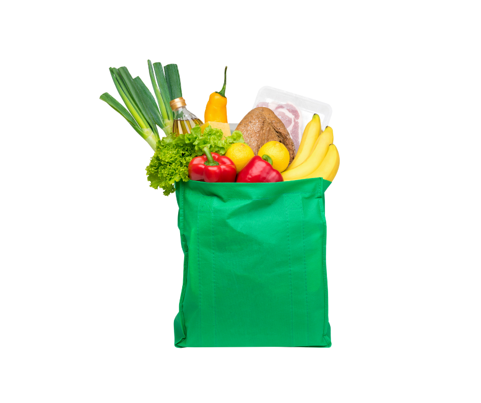 A green reusable bag filled with fruits and vegetables spilling out.