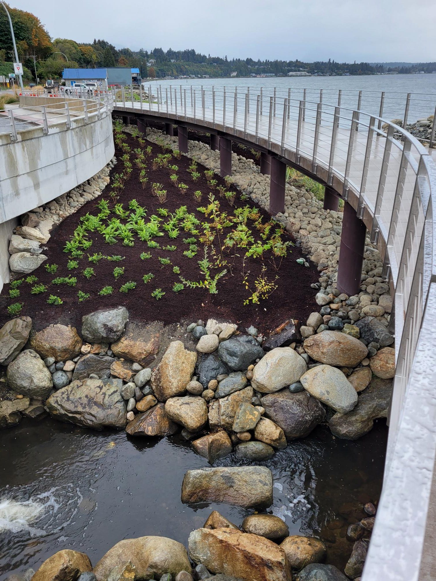 Underneath the Viewing Platform and Walkway, showing a newly planted garden surrounded by rocks.