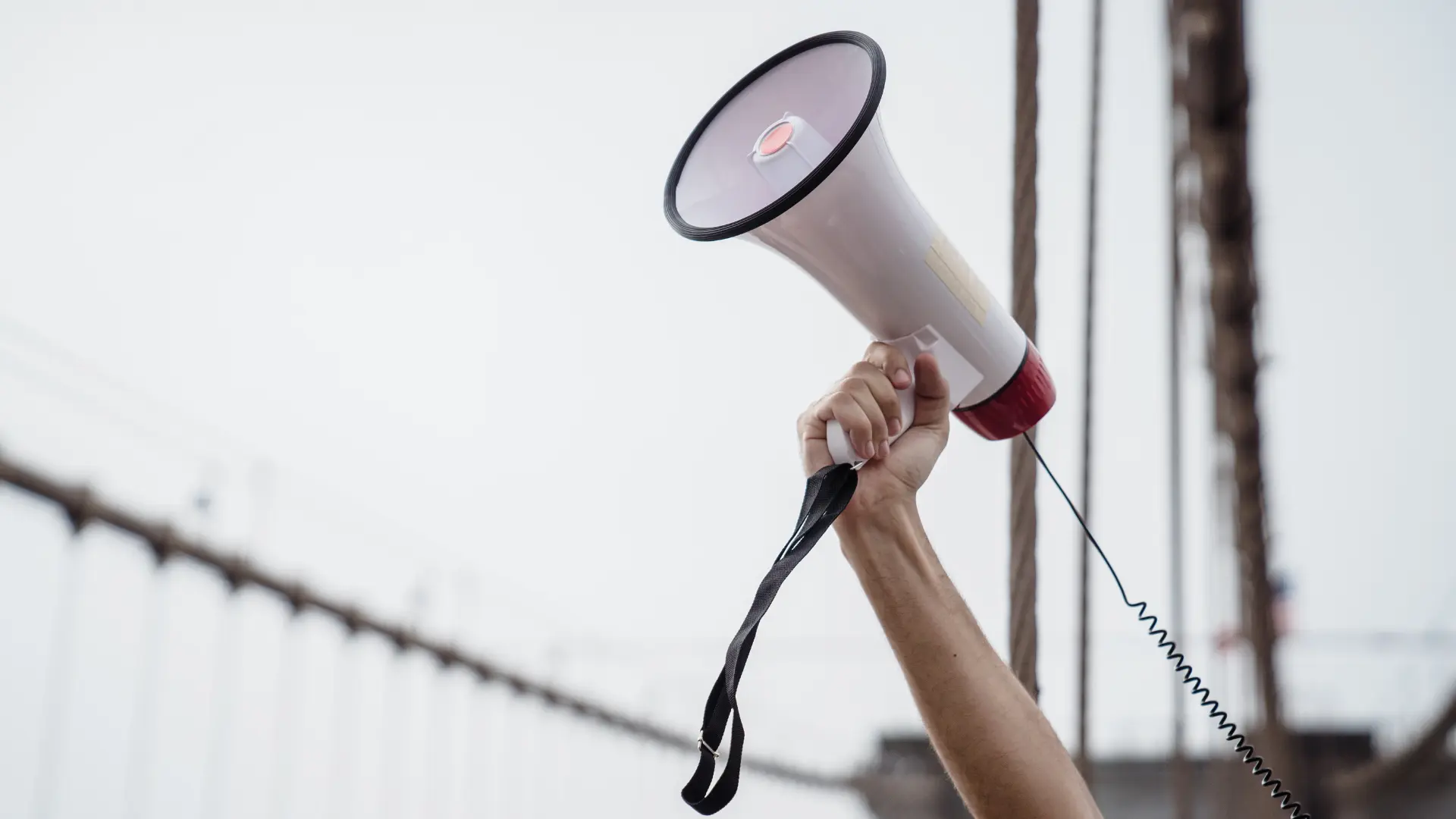 Person holding megaphone in the air.