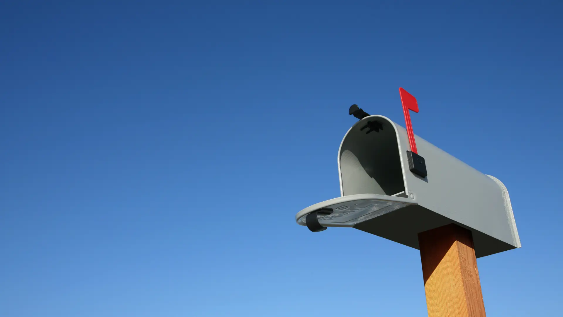 Open mailbox against blue sky.