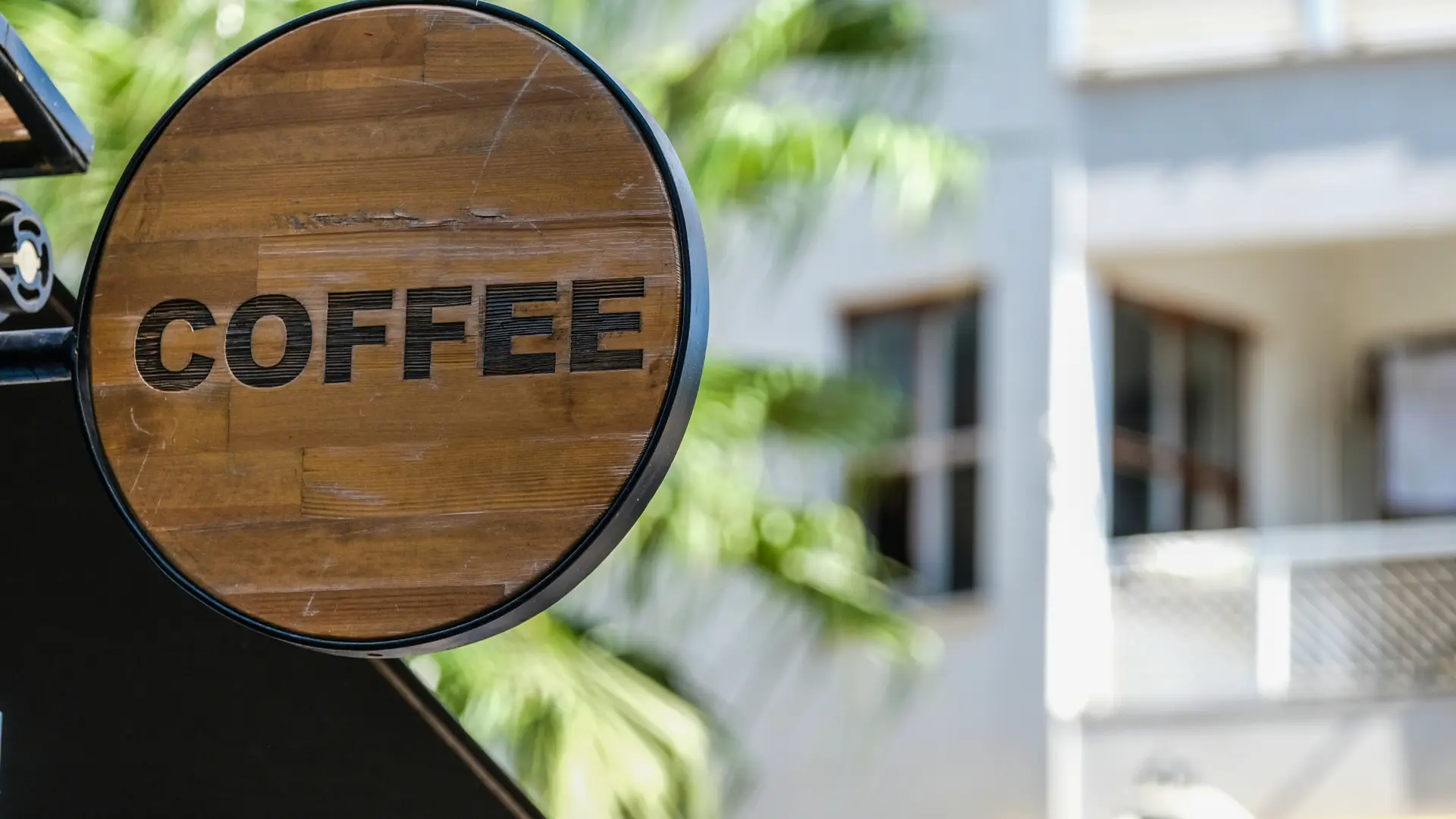 A round wooden sign reading 