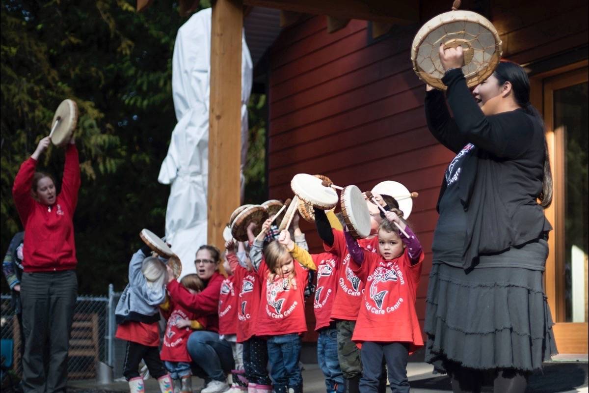 Qualicum First Nation children dancing and playing an instrument, next to two instructors.